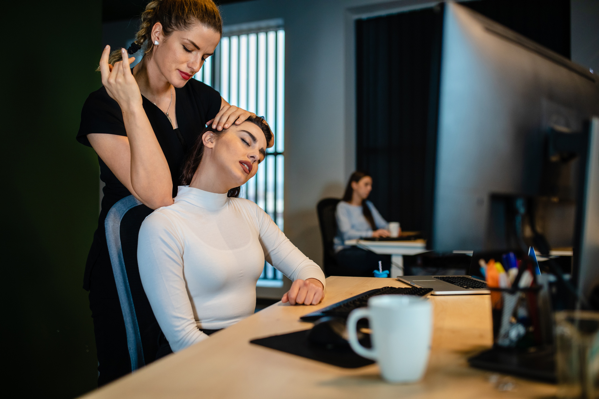 Corporate massage therapist using elbow for a neck massage on clients